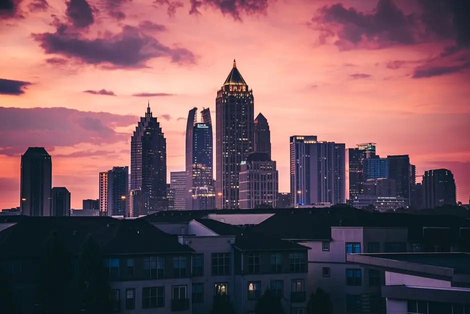 Midtown Atlanta under a pink sunset, the gold-topped spire of the Bank of America Plaza at the centre.
