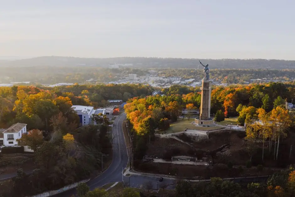 The Vulcan statue on Red Mountain above Birmingham, Alabama, the trees in autumn colour at golden hour.