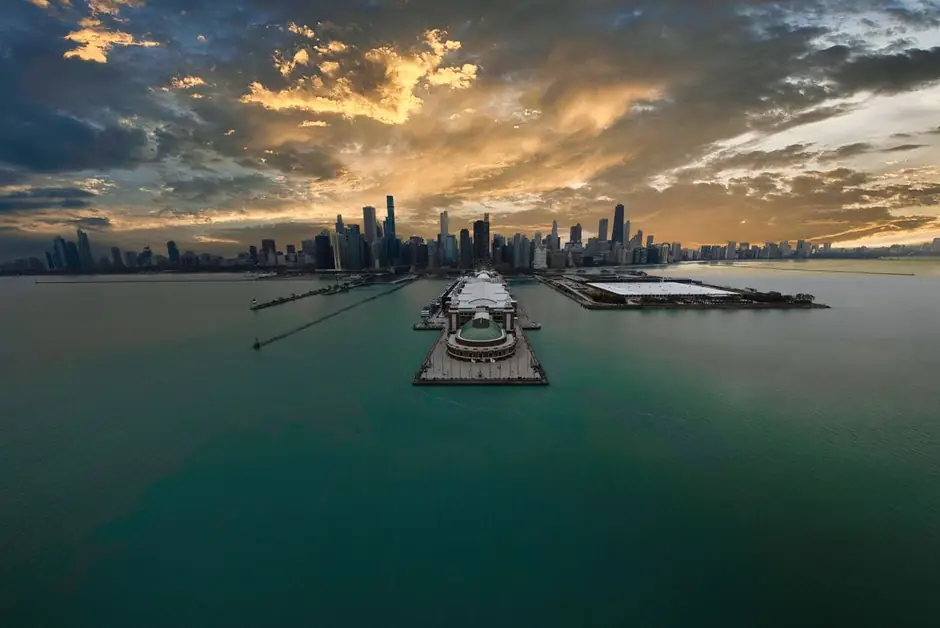 The Chicago skyline at sunset over Lake Michigan, Navy Pier reaching out into the water.