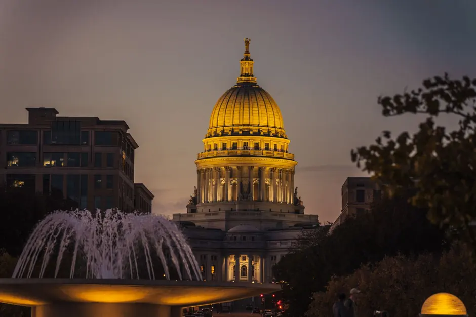 The Wisconsin State Capitol illuminated during twilight, showcasing its architectural beauty.