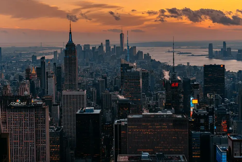 Manhattan at sunset from Top of the Rock, the Empire State Building against an orange sky.