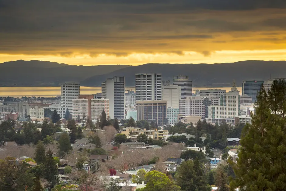 Skyline of Oakland, California at sunset with dramatic skies.